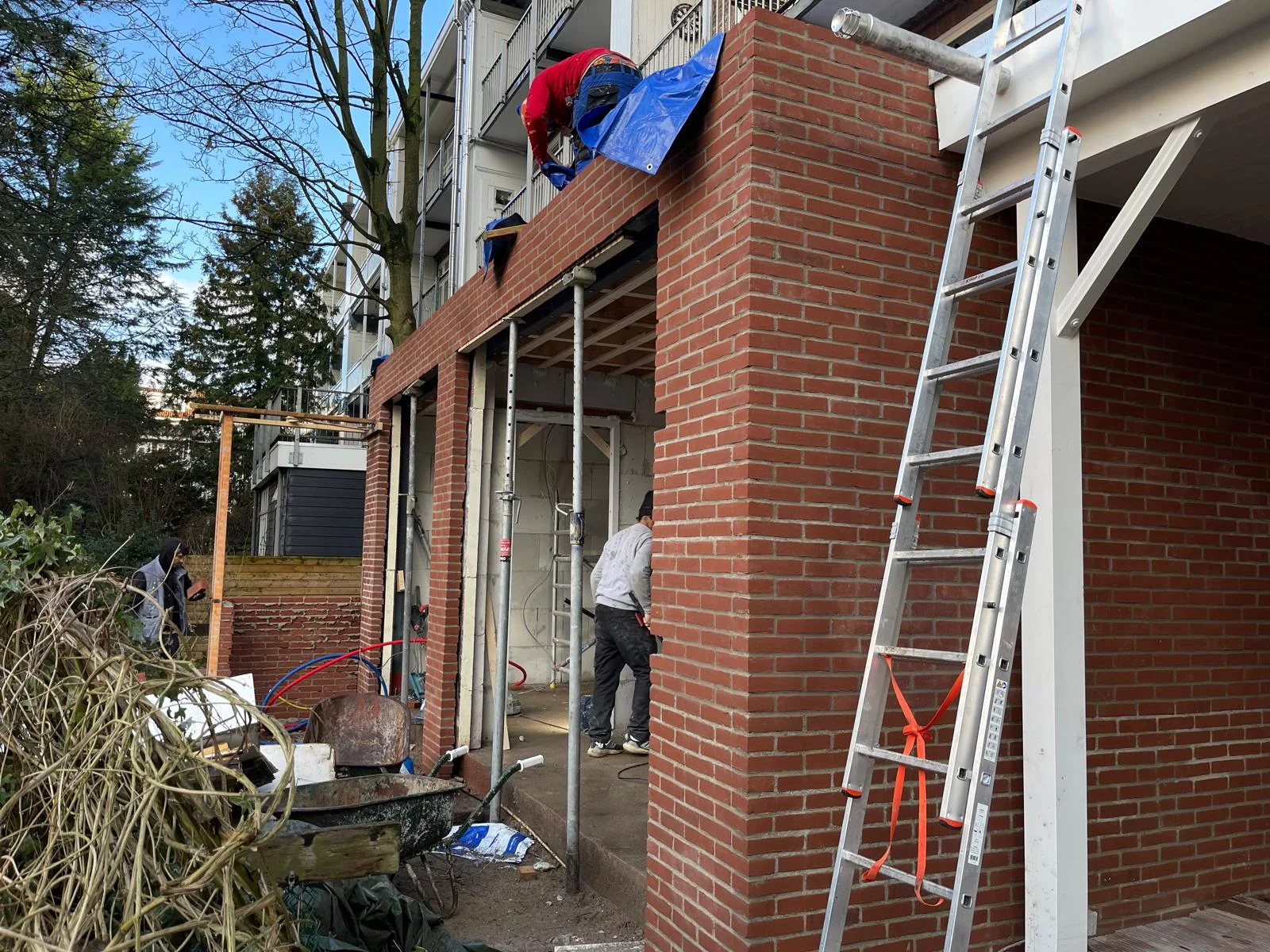 Zijaanzicht met strakke hoekverbanden en een blauw dekzeil dat de bovenkant beschermt.