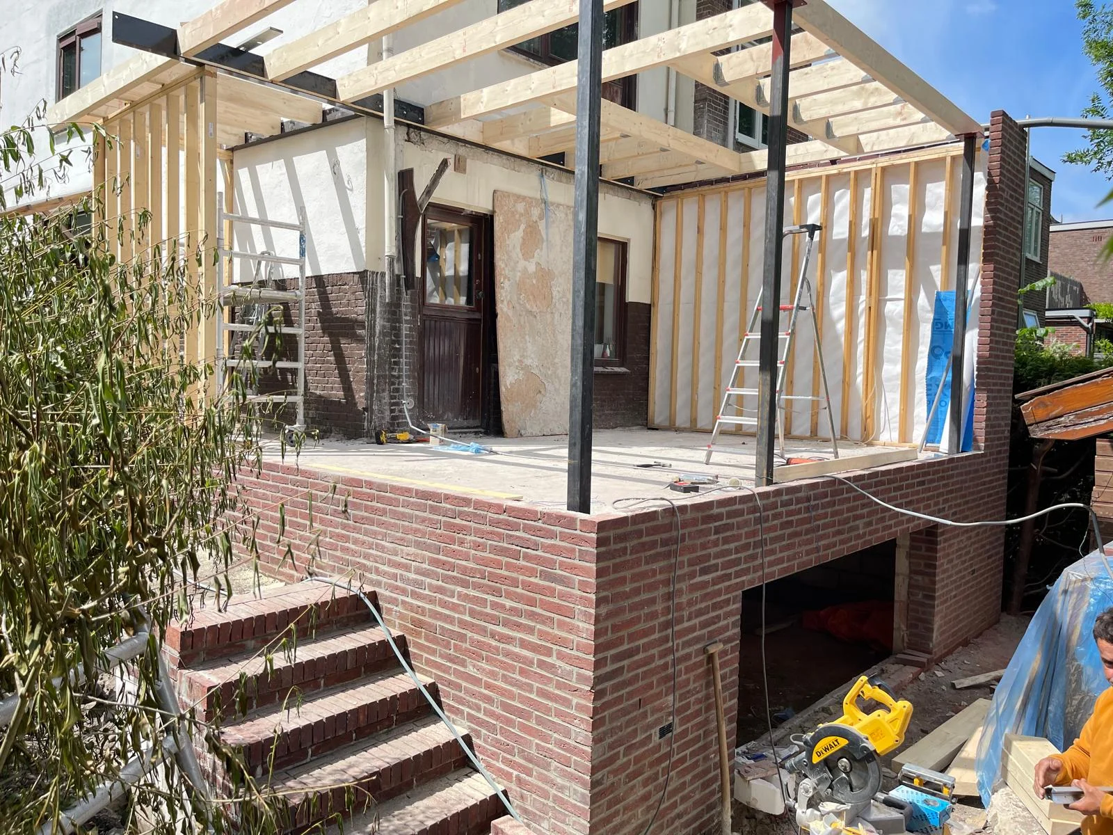 Het volledige casco van de aanbouw op podium, met verhoogd terras en gemetselde tuintrap naar de lager gelegen tuin