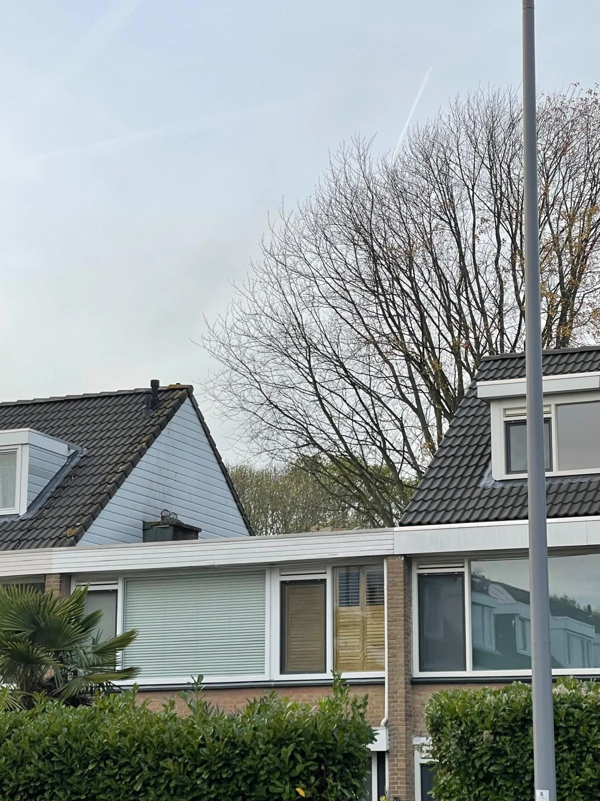Een jaren-70 rijwoning in Hilversum met steil dakvlak, originele dakpannen en kleine bestaande dakkapel.